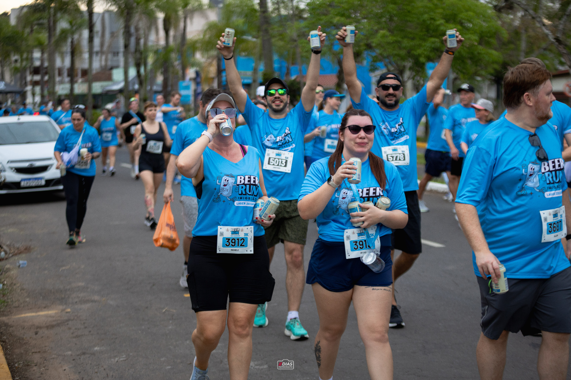Corredores erguendo latas na Beer Run Imigração